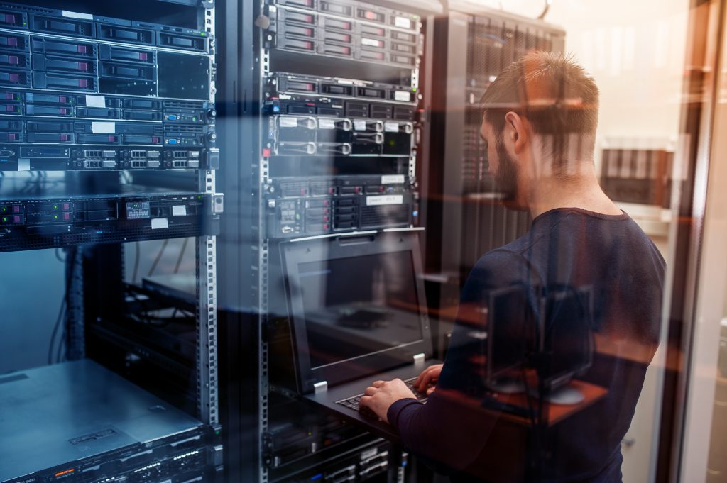 Network engineer working in server room, providing managed IT services